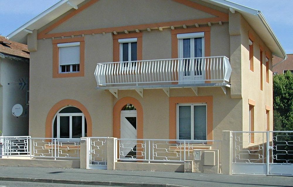 Maison de bourg après rénovation de façade, teinte sable et menuiseries reprises