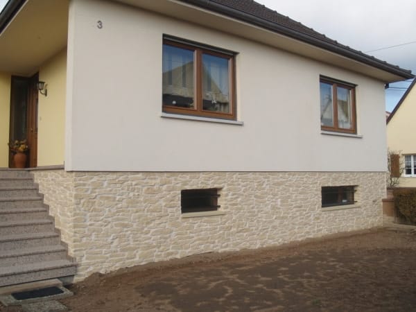Soubassement en pierre conservé et enduit neuf appliqué au-dessus